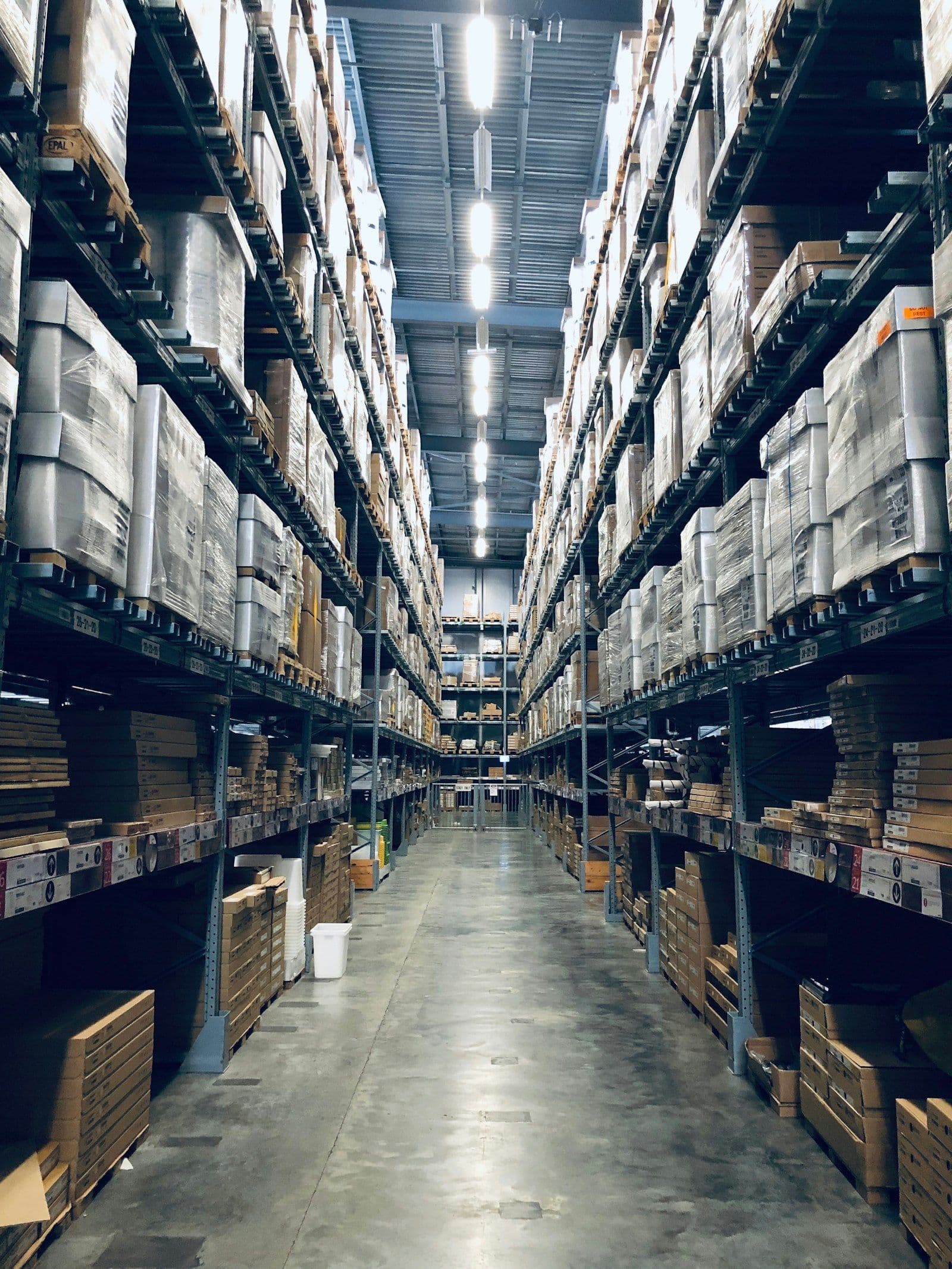 Warehouse shelving units with labeled inventory bins in a well-organized distribution center
