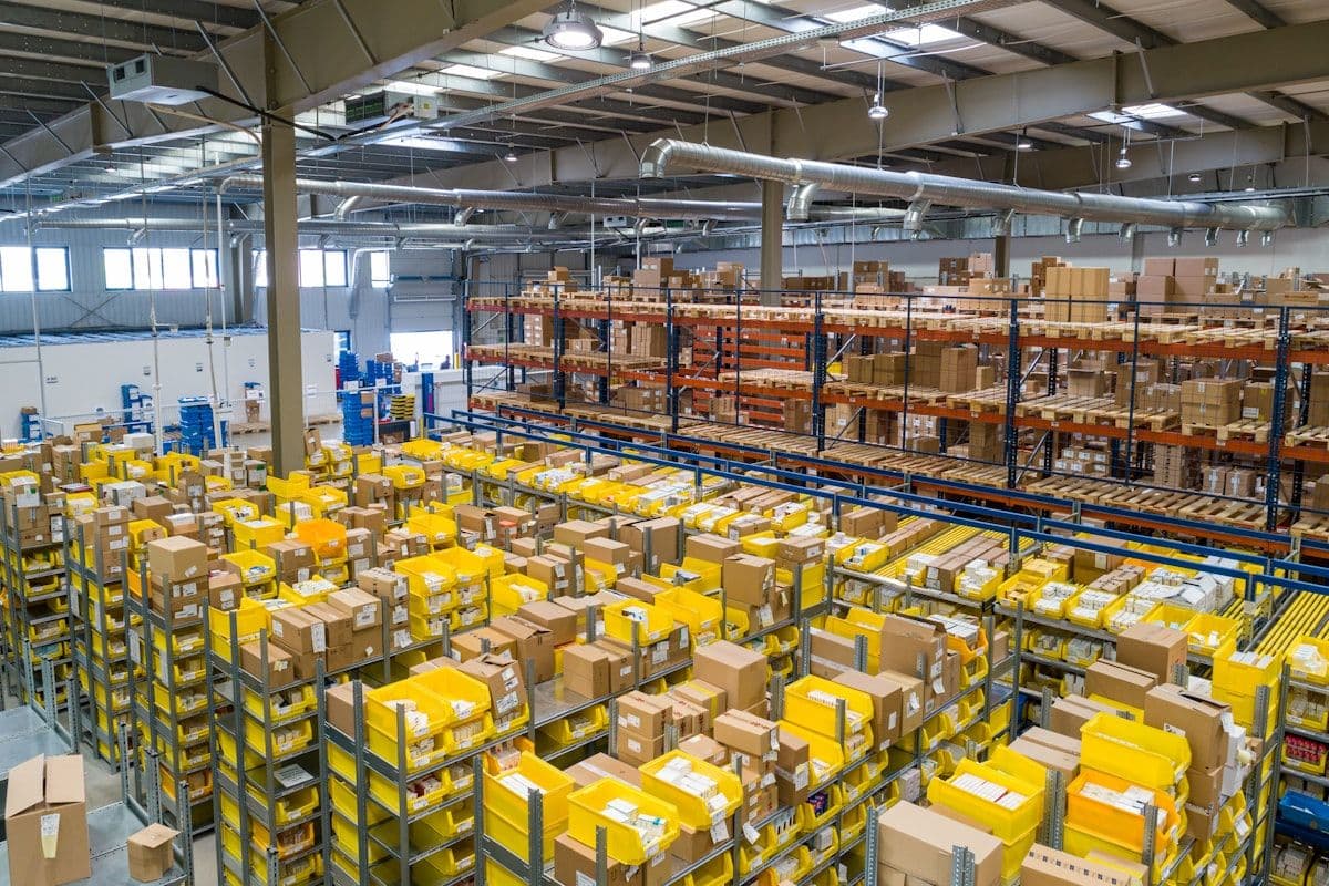 Warehouse operator scanning inbound packages at a receiving dock with boxes stacked in the background